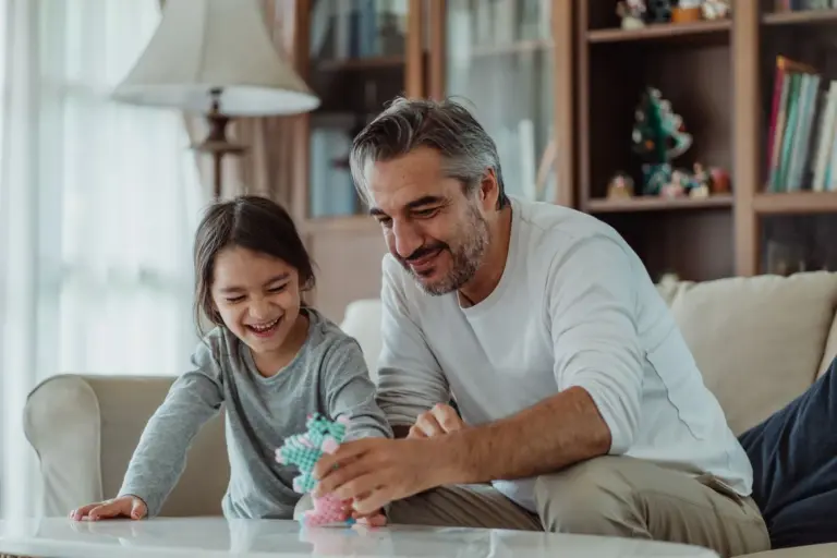 Father and daughter playing together in a living room