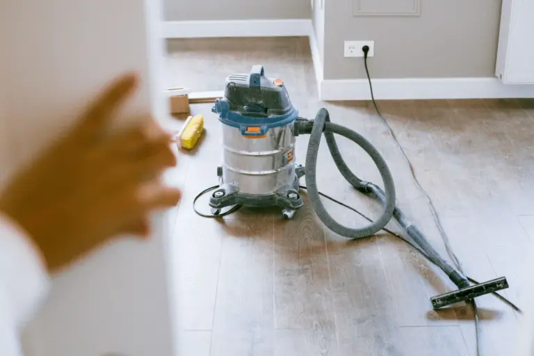 Shop vacuum and cleaning supplies on a new wood floor after renovation work