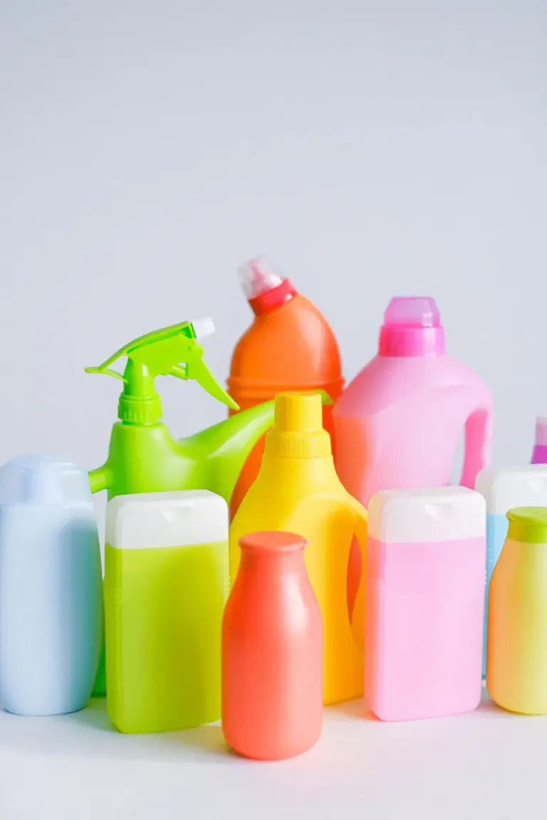 Unlabelled cleaning bottles and sprays on a white table