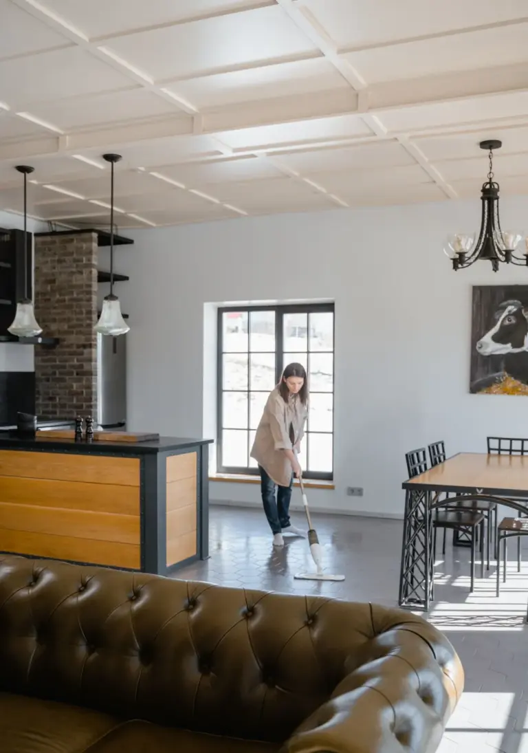 Cleaner mopping the floor of a bright open living space